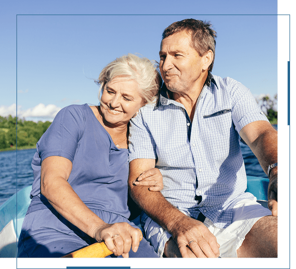 Elderly couple enjoying a peaceful boat ride on a sunny day.